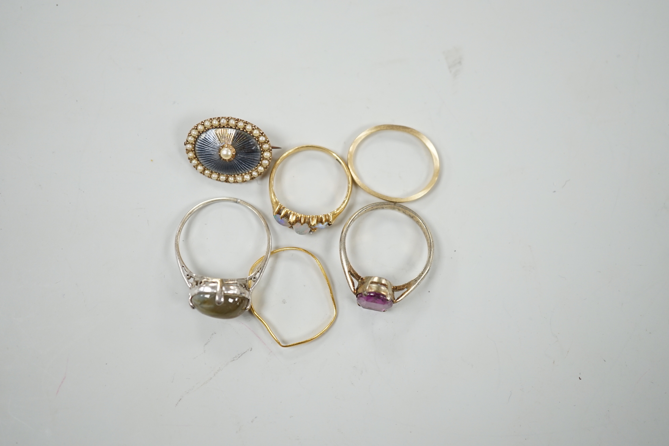 An early 20th century 18ct and three stone white opal set half hoop ring, with diamond chip spacers(one missing), size M, gross weight 2.5 grams, a 9ct band, 1 grams, a 22ct band(a.f.), 0.8 grams, two other rings includi